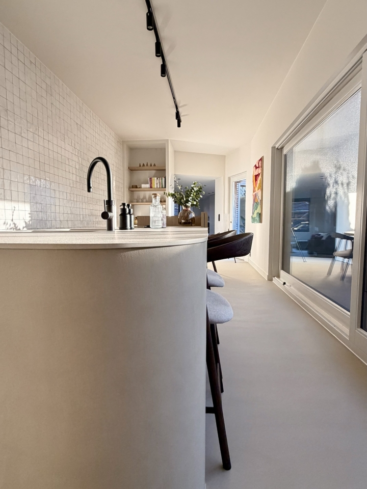 Minimalistisch kookeiland met afgeronde hoek en zitplaatsen in moderne maatwerkkeuken in Roeselare, West-Vlaanderen