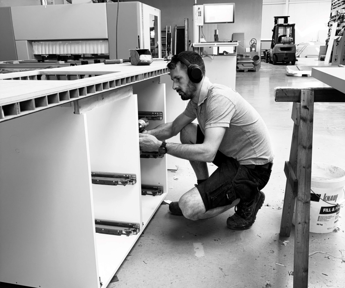 Montage en afwerking van een maatkast in het atelier van Abstrakt Interieur. Professionele schrijnwerkproductie en montageklare bouwpakketten voor schrijnwerkers in West-Vlaanderen.